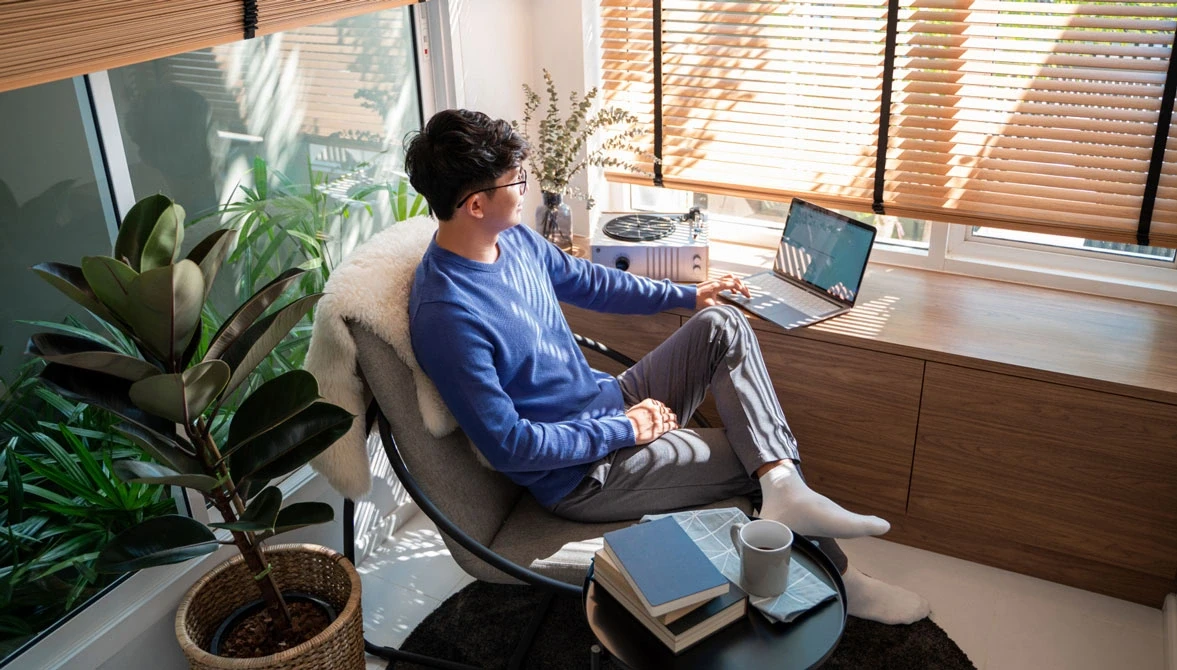 person lounges in chair looking at laptop